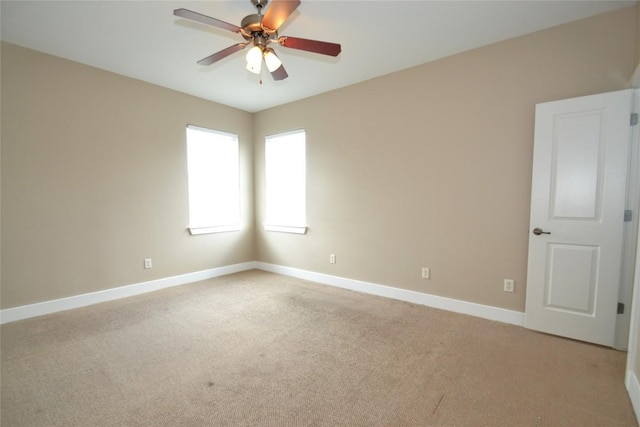 unfurnished room with ceiling fan, light colored carpet, and baseboards