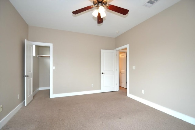 unfurnished bedroom featuring visible vents, carpet, a walk in closet, and baseboards