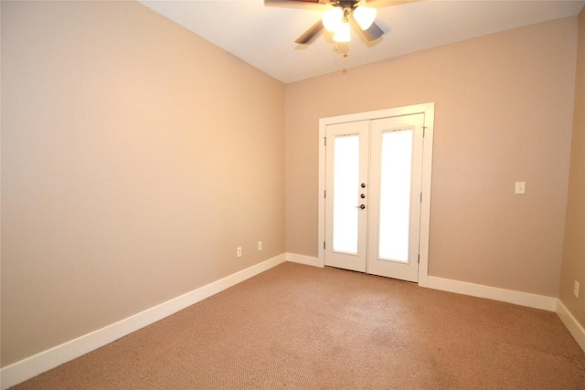 spare room featuring carpet floors, a ceiling fan, baseboards, and french doors