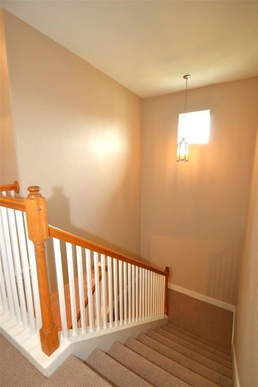 stairs featuring carpet flooring and baseboards