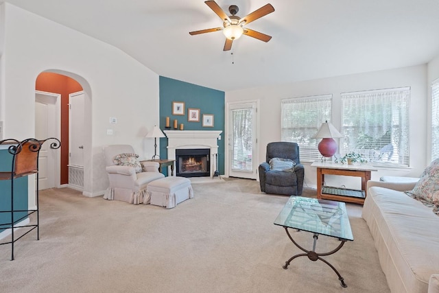 1720 Woodvista Pl, Round Rock, TX 78665 - living area with vaulted ceiling, arched walkways, a ceiling fan, carpet floors, and a warm lit fireplace