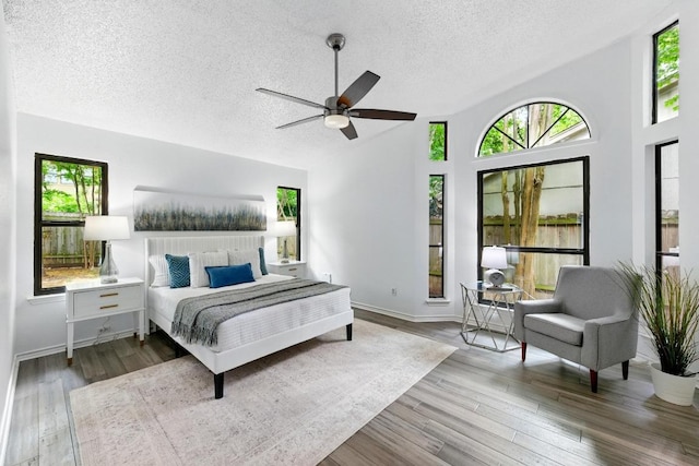 7419 Dallas Dr, Austin, TX 78729 - bedroom featuring multiple windows, a textured ceiling, wood finished floors, a ceiling fan, and baseboards