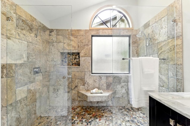7419 Dallas Dr, Austin, TX 78729 - bathroom featuring tiled shower, vaulted ceiling, and vanity