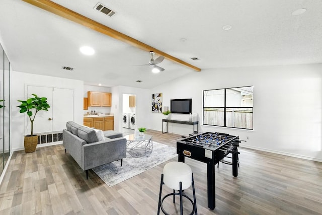 7419 Dallas Dr, Austin, TX 78729 - living room featuring washing machine and clothes dryer, light wood finished floors, ceiling fan, and baseboards