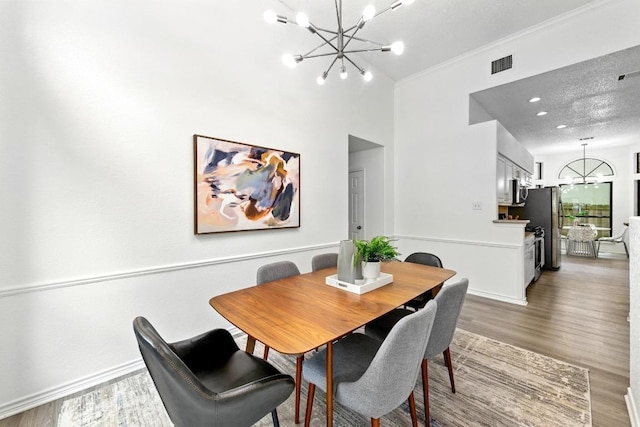 7419 Dallas Dr, Austin, TX 78729 - dining room featuring a chandelier, wood finished floors, ornamental molding, and baseboards