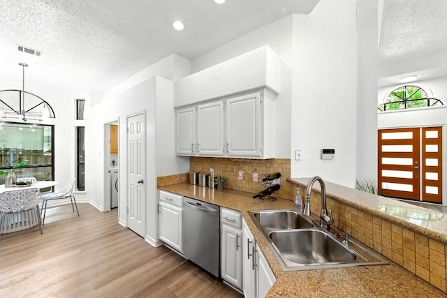 7419 Dallas Dr, Austin, TX 78729 - kitchen featuring dishwasher, a sink, backsplash, white cabinets, and a textured ceiling