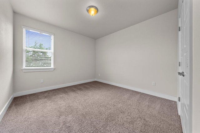 carpeted empty room featuring baseboards