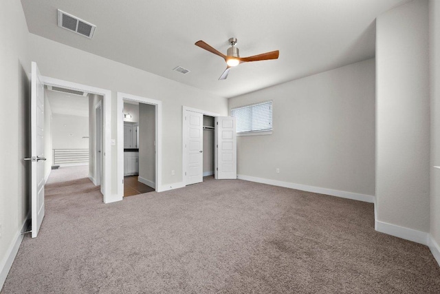 unfurnished bedroom featuring carpet floors, baseboards, a closet, and visible vents