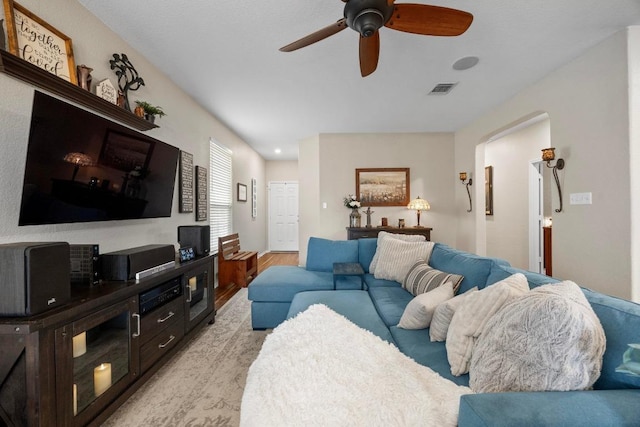 living area with a ceiling fan, light wood-style flooring, and visible vents