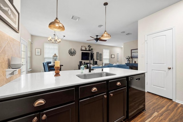 kitchen featuring visible vents, dark wood-style flooring, dishwashing machine, a sink, and decorative light fixtures