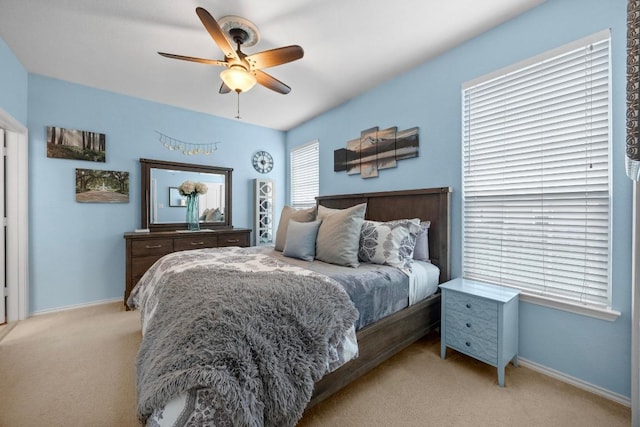 bedroom featuring baseboards, ceiling fan, and light carpet