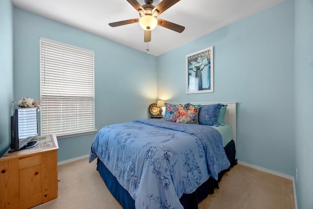 bedroom featuring light colored carpet, baseboards, ceiling fan, and multiple windows