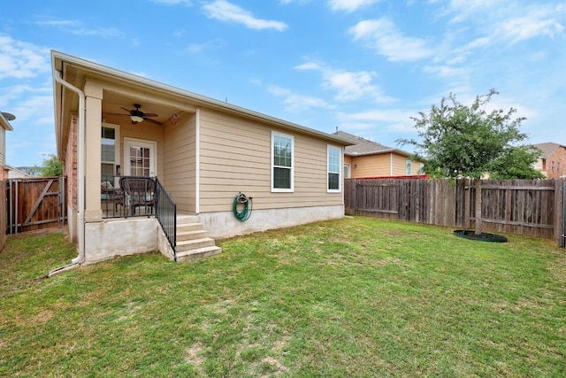 back of property featuring a lawn, a fenced backyard, and ceiling fan