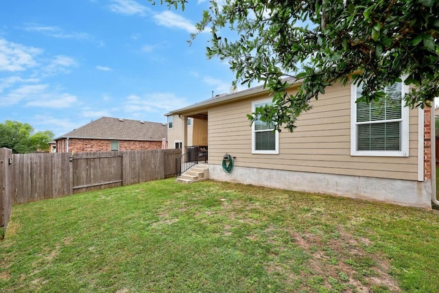 back of property with a fenced backyard and a yard