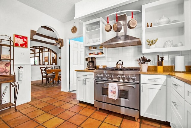 kitchen featuring stainless steel stove, open shelves, white cabinetry, and backsplash