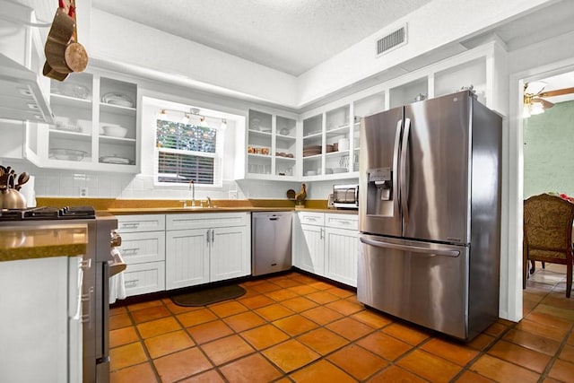 kitchen featuring open shelves, a sink, stainless steel appliances, white cabinetry, and visible vents