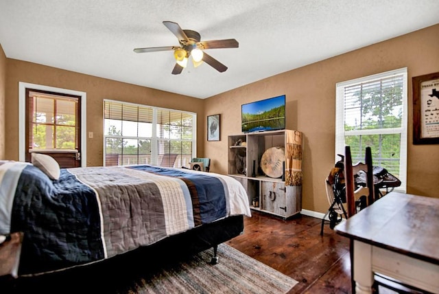 bedroom featuring baseboards, a ceiling fan, dark wood-style flooring, and multiple windows