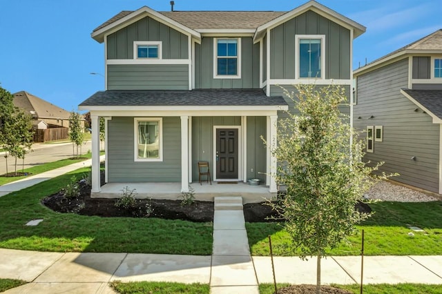 2208 Pecan Island Dr, Leander, TX 78641 - view of front facade with board and batten siding, covered porch, a front lawn, and a shingled roof