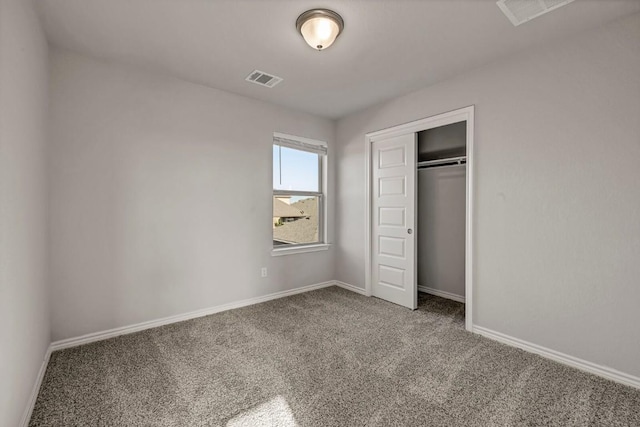 unfurnished bedroom featuring carpet floors, baseboards, visible vents, and a closet