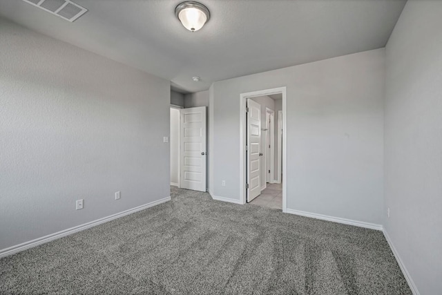 unfurnished bedroom featuring carpet flooring, baseboards, and visible vents