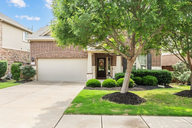 obstructed view of property featuring a front lawn, stone siding, roof with shingles, brick siding, and concrete driveway
