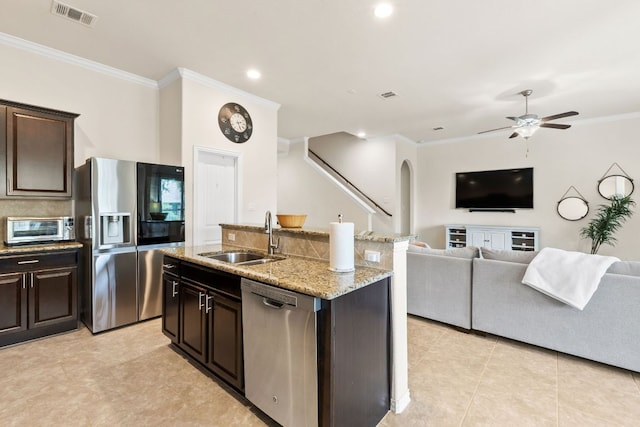 kitchen featuring visible vents, crown molding, open floor plan, a sink, and stainless steel appliances