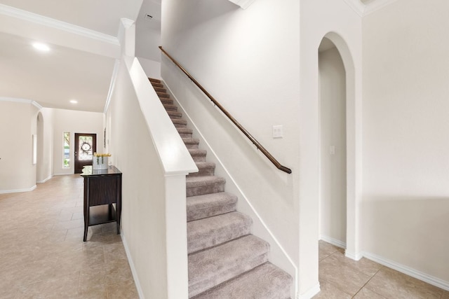 stairway featuring ornamental molding, baseboards, recessed lighting, tile patterned floors, and arched walkways