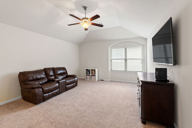 living area featuring a ceiling fan, baseboards, light carpet, and lofted ceiling