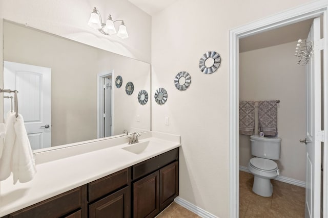 bathroom featuring vanity, baseboards, tile patterned flooring, and toilet