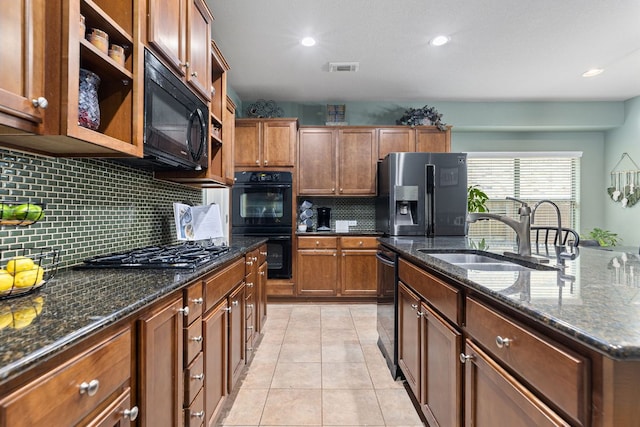 kitchen with a sink, dark stone countertops, recessed lighting, decorative backsplash, and black appliances