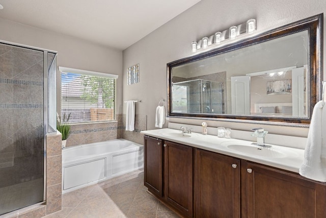 bathroom featuring a sink, double vanity, a shower stall, and a garden tub