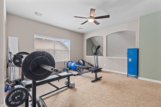 exercise area with baseboards, carpet flooring, ceiling fan, and visible vents