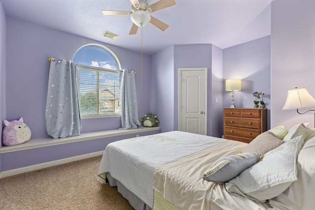 carpeted bedroom with visible vents, a ceiling fan, and baseboards