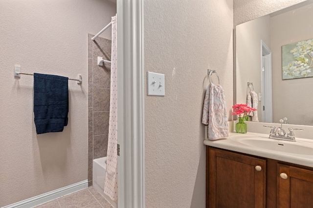 bathroom with vanity, tile patterned flooring, a textured wall, and shower / bath combination with curtain