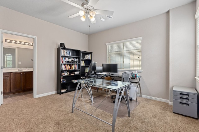 office with baseboards, light carpet, a ceiling fan, and visible vents