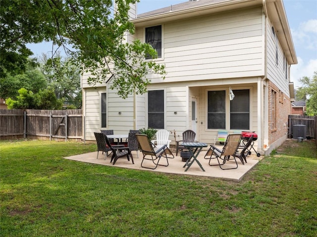 rear view of house with central AC, a fenced backyard, brick siding, a patio area, and a yard