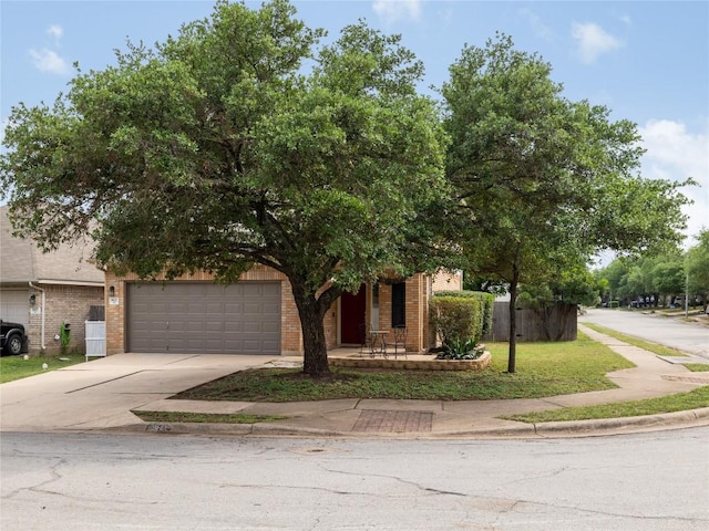obstructed view of property with brick siding, an attached garage, driveway, and fence