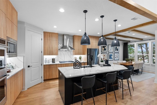 kitchen with light wood-style floors, modern cabinets, and wall chimney range hood
