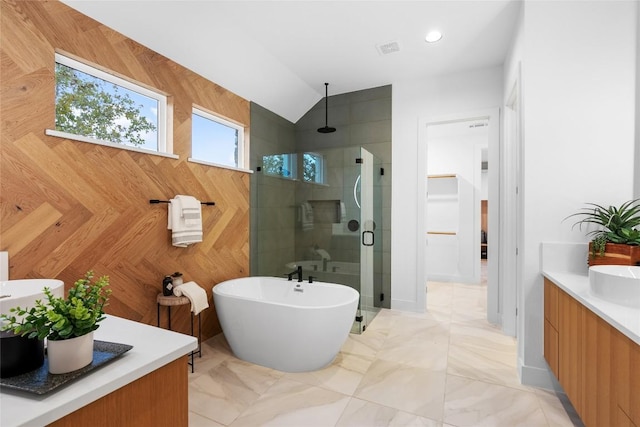 full bath featuring vanity, visible vents, a freestanding bath, a stall shower, and vaulted ceiling