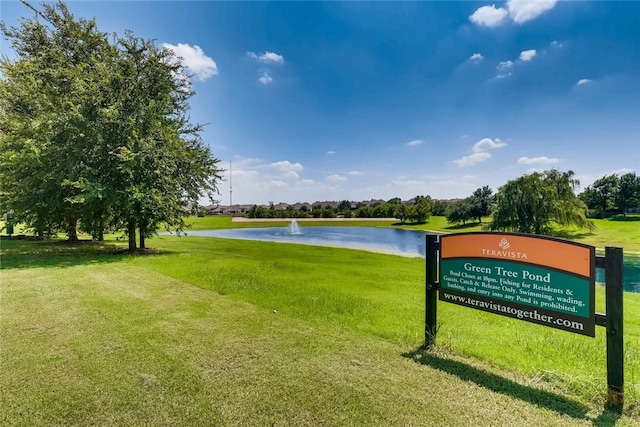 view of property's community with a water view and a lawn