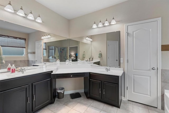 bathroom featuring tile patterned flooring, a bathtub, and vanity