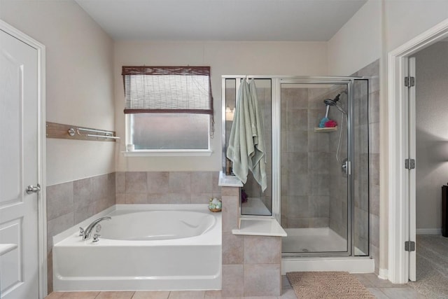 full bathroom with a stall shower, a bath, and tile patterned flooring