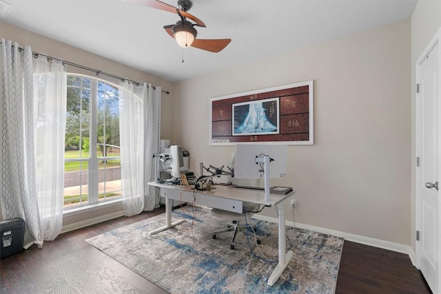 home office featuring plenty of natural light, wood finished floors, baseboards, and a ceiling fan