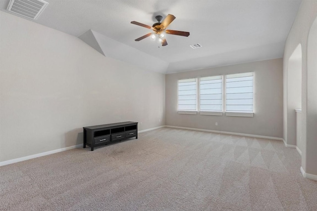 empty room with ceiling fan, carpet, vaulted ceiling, and baseboards