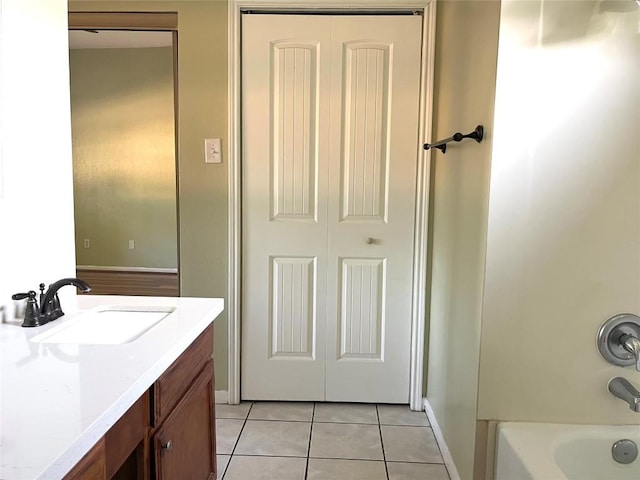 bathroom with tile patterned floors, baseboards, vanity, and bathing tub / shower combination