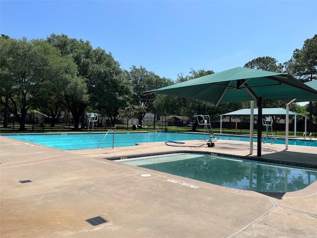community pool with fence and a patio area