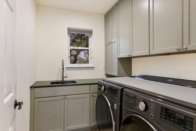 laundry area featuring a sink, separate washer and dryer, and cabinet space