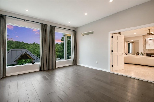 empty room with baseboards, recessed lighting, and wood finished floors