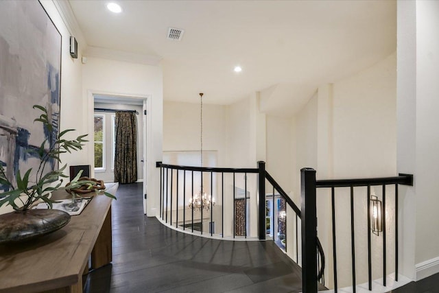 corridor with visible vents, wood finished floors, baseboards, an upstairs landing, and recessed lighting