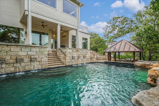 pool featuring a gazebo, stairway, and ceiling fan